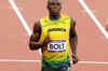 Bolt defends 100m title with new Olympic record